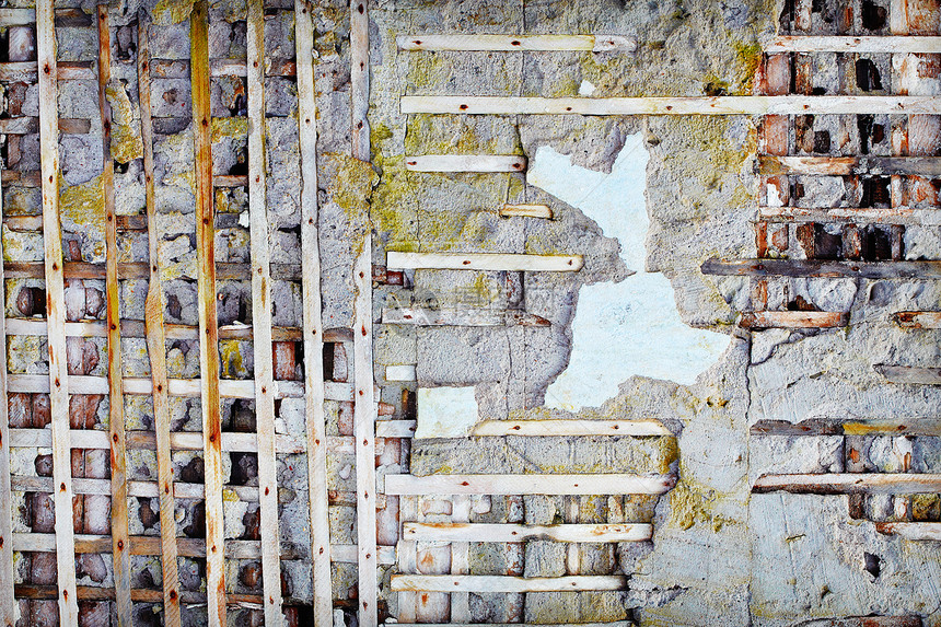 被损坏的旧水泥墙中的木板图片