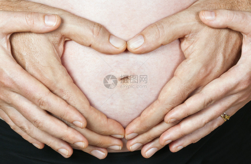 由怀孕夫妇亲手制造的孕妇肚子上的爱心图片