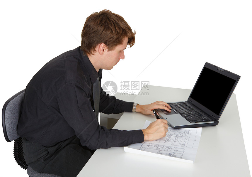 男人坐在办公桌旁工作图片