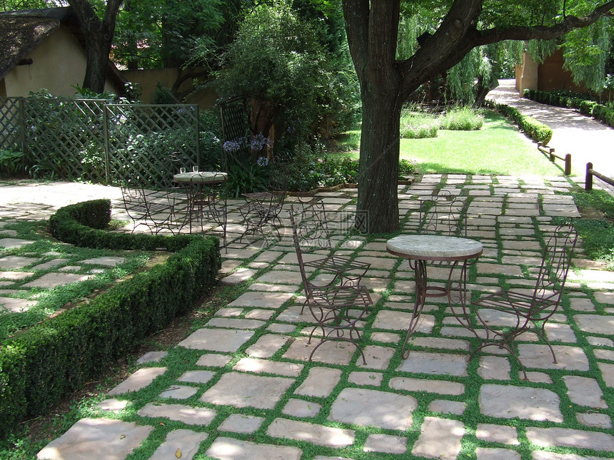 园圃太阳桌子石头白色叶子阴影椅子玫瑰绿色植物人行道图片