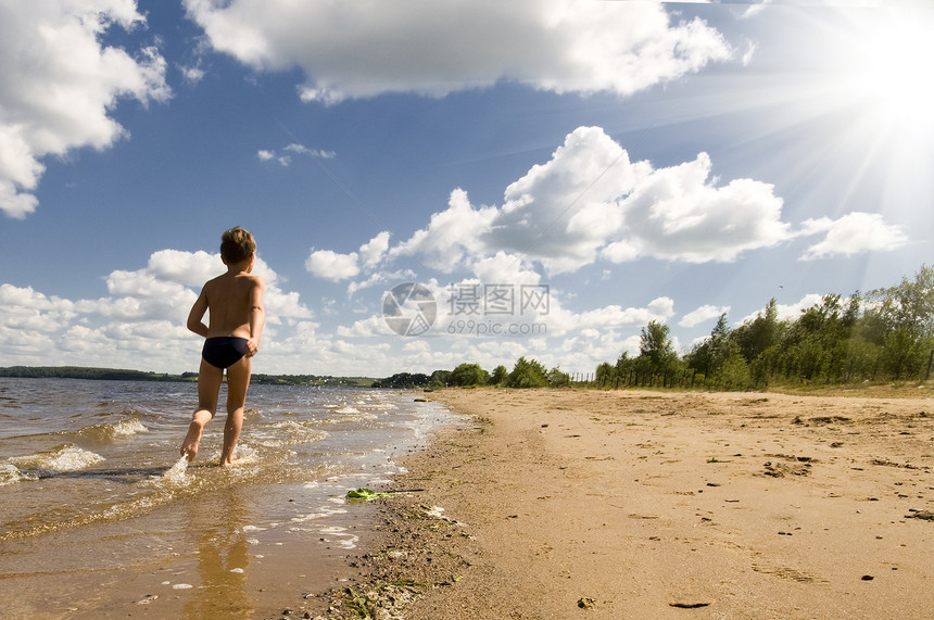 年轻男孩跑在美丽的海滩上太阳海洋寂寞娱乐闲暇旅行跑步假期男性海岸图片