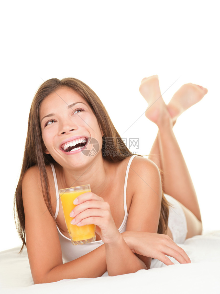 睡床上喝果汁的女人图片