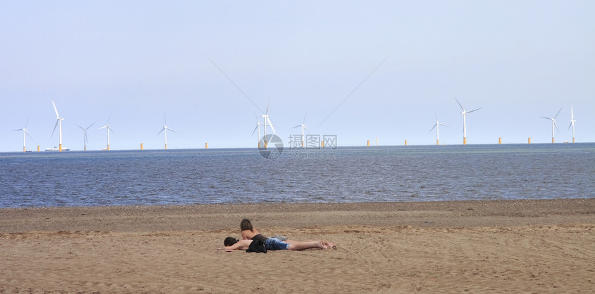 海滩上的情侣场地女性女士风车生态男人天空发电机环境涡轮机图片