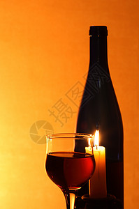 红酒和蜡烛玻璃饮食纪念日饮料瓶子餐具高脚杯酒精周年火焰背景图片