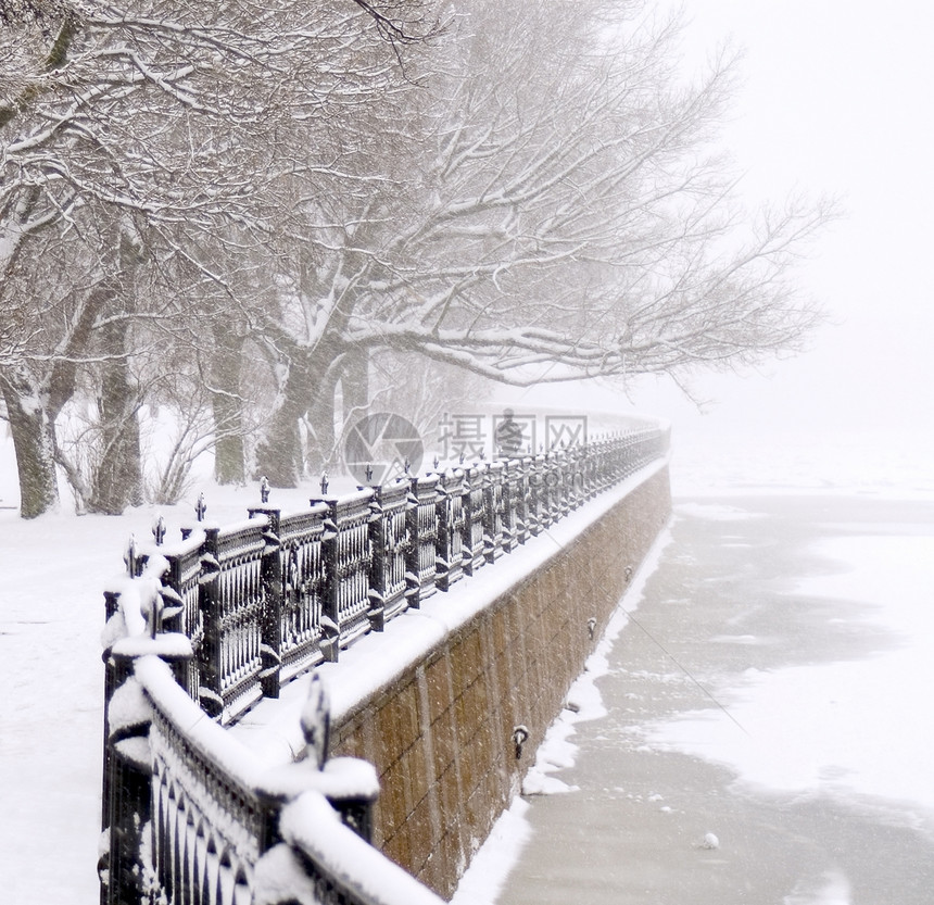 下雪的堤岸公园栅栏季节冷冻风暴树木花园阴霾降雪寂寞图片