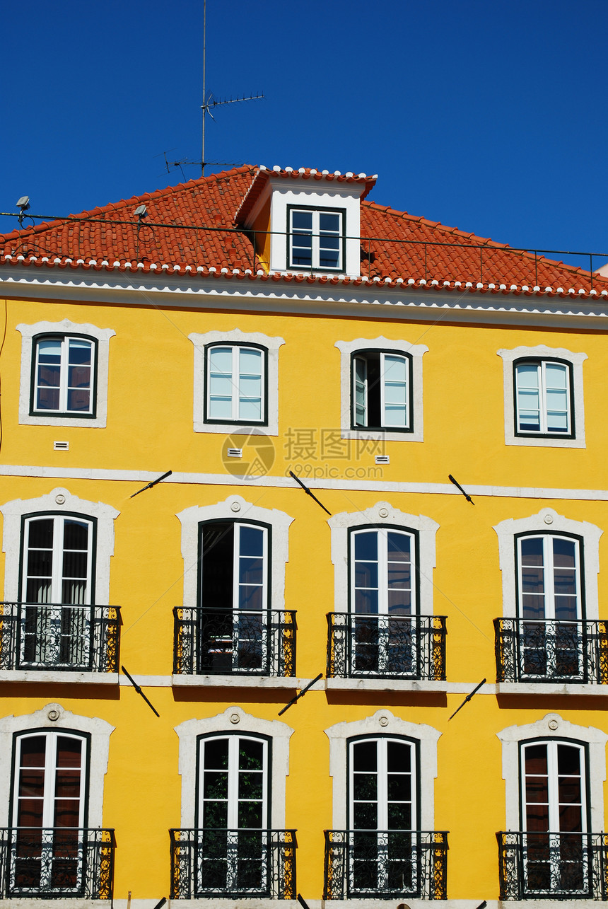 古老建筑外表黄色天空阳台粉色阁楼城市房子住宅建筑学蓝色图片
