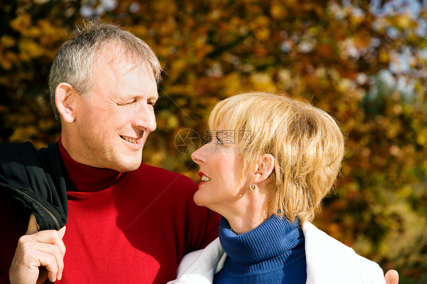 成熟的浪漫情侣散步公园娱乐丈夫草地拥抱快乐喜悦太阳成人妻子图片
