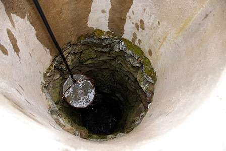 水井加水管子绿色饮料石头圆形国家绳索灰色背景图片
