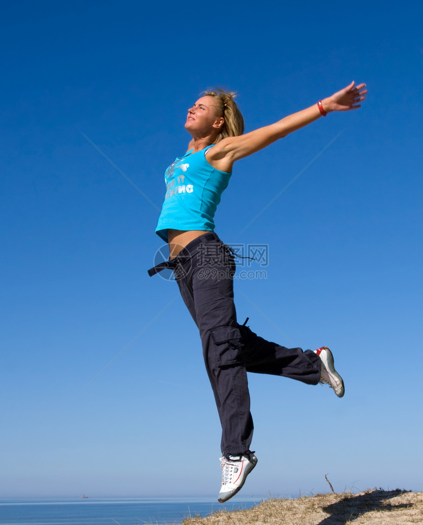 跳跳女飞行活力享受女性喜悦微笑自由乐趣衣服蓝色图片