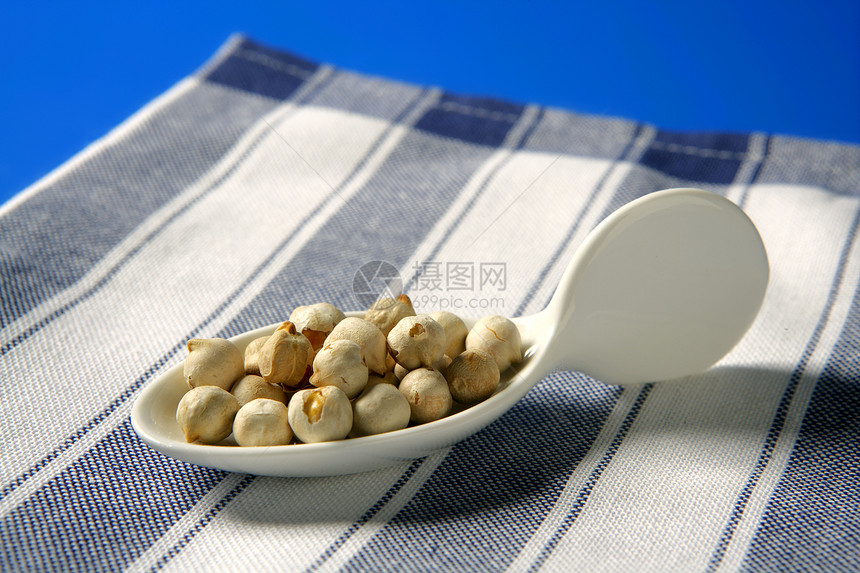 Chickpeas 仍然分布在蓝色背景中纤维食物餐巾饮食农业粮食收成种子营养宏观图片