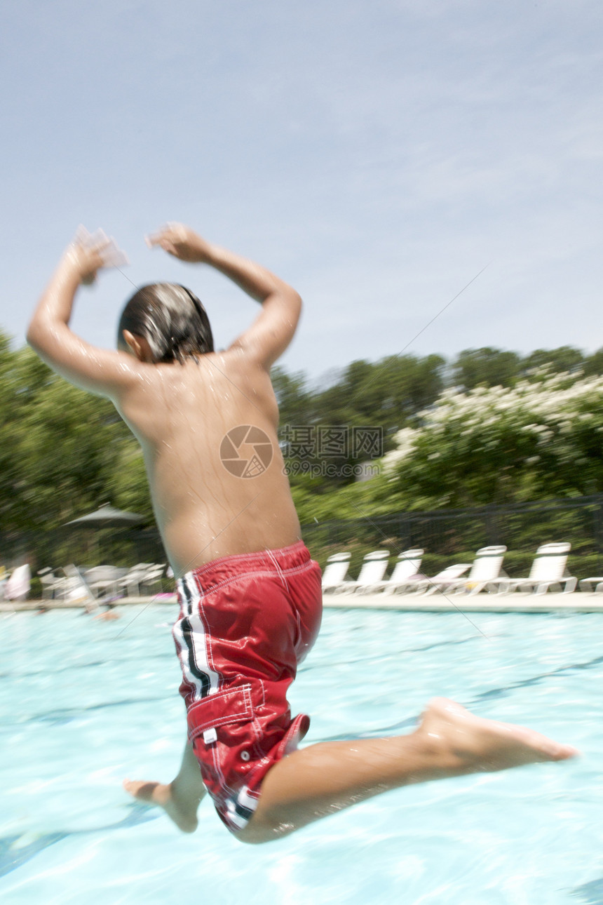 小男孩跳进游泳池假期乐趣水池游泳游泳者孩子们闲暇生活童年孩子图片