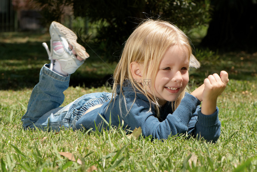 小女孩躺在公园的草地上图片