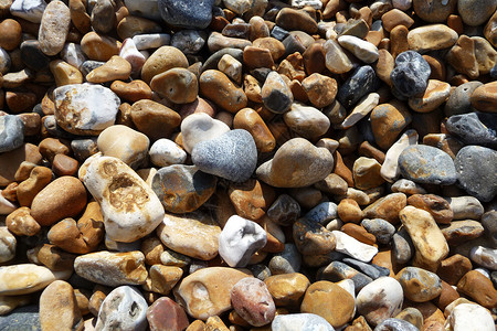 布莱顿海滩上的石头肋骨石质海岸线海岸鹅卵石宏观海滩背景图片