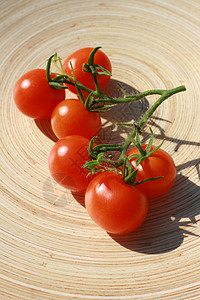 樱桃番茄沙拉盘子拼盘绿色藤蔓蔬菜红色水果圆形木头背景图片