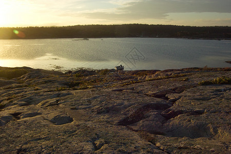 日落时海边岩石风景背景图片