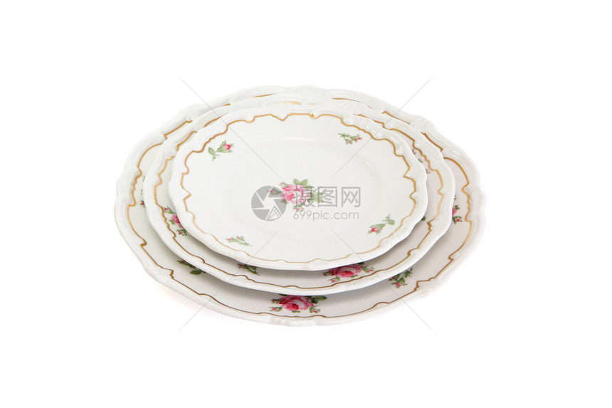 堆叠的三个白色餐盘和碟子 上面有鲜花和波浪形边缘 被隔离图片