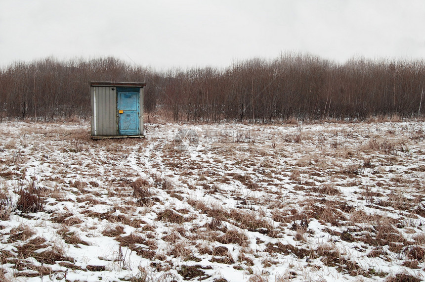 在一个雪覆盖的田地里的小厕所小屋图片