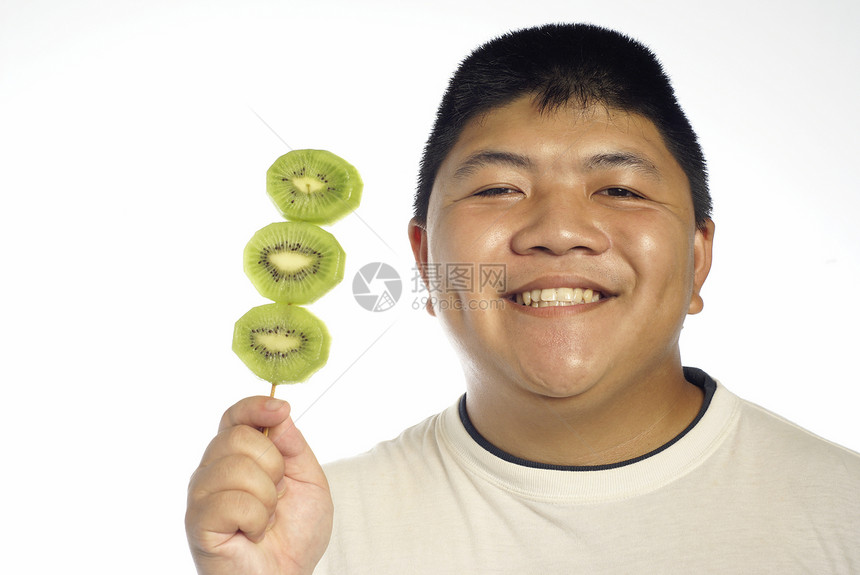 亚裔男子对绿色kiwi水果感到兴奋图片