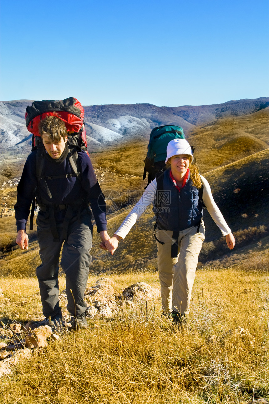 两个徒步者爬上山顶冒险石头成人晴天运动女性远足天空小路旅行图片