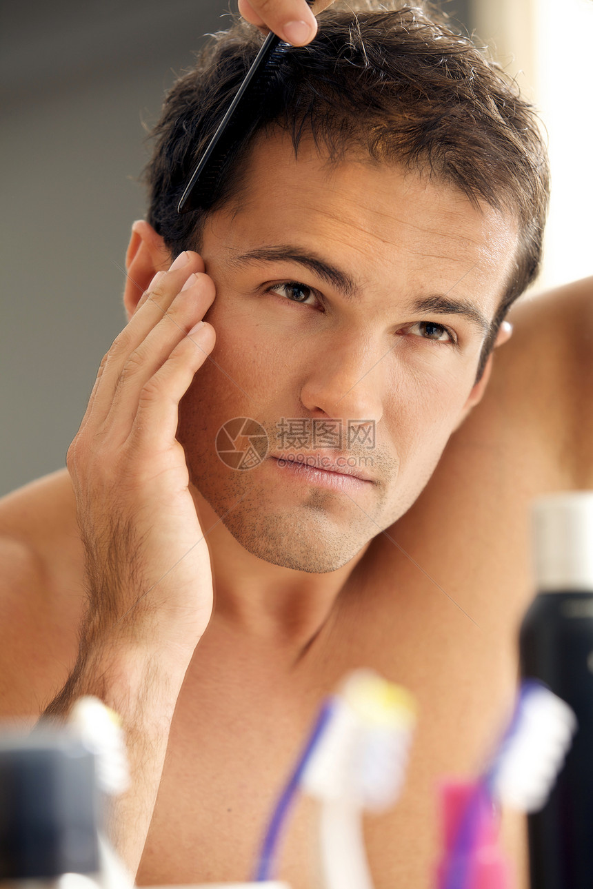年轻人梳理头发反射外表虚荣卫浴人类男人头肩摄影牙刷镜子图片