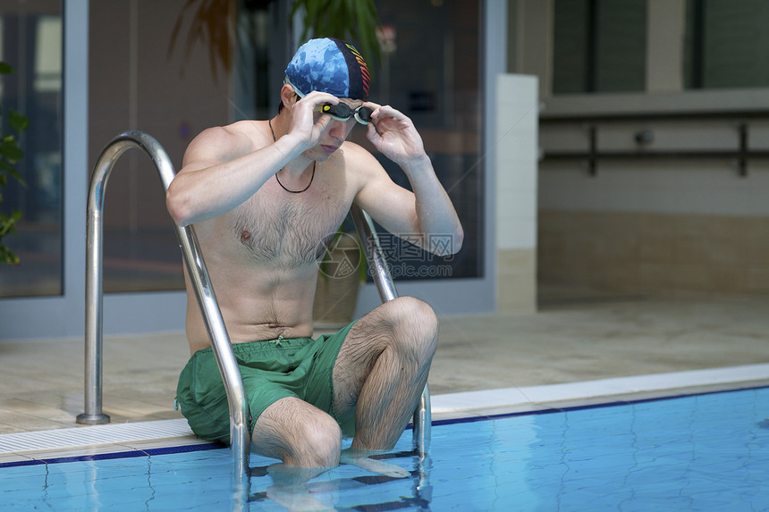 游泳池里的年轻人温泉水池反射运动游泳男人活力蓝色微笑假期图片