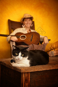 音乐家哈咪猫有吉他和猫的漂亮西女人帽子裙子古董细绳乐器猫科女士动物稻草音乐背景