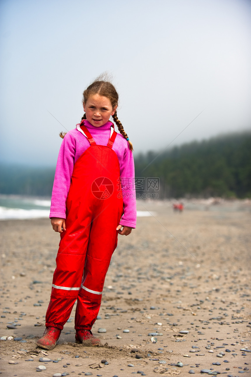 身着红雨衣的年轻女孩在美国瓦辛顿海滨青年乐趣女儿姐姐红色雨具海滩孩子图片