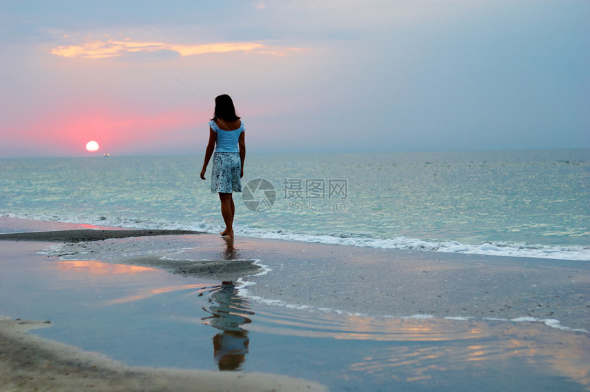 清晨在海边的一个女人海岸太阳海浪海滩女性女孩们天空海洋假期成人图片