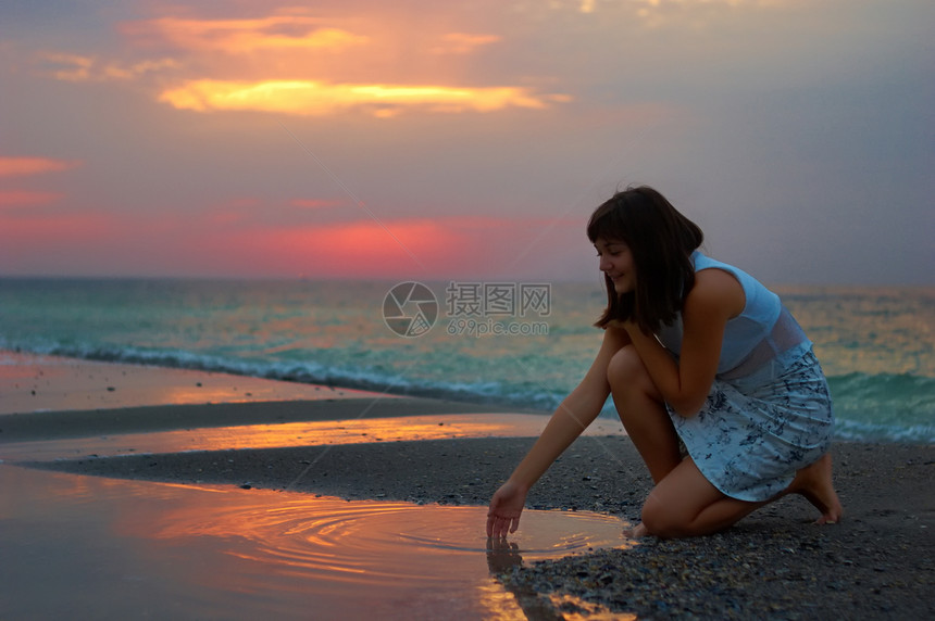 清晨在海边的一个女人海岸海滩海洋太阳日落海浪假期女孩们成人天空图片