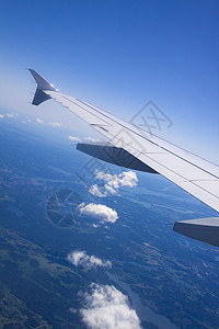 从飞机窗口看到云的景象天空航空旅行翅膀湍流速度运输喷射蓝色窗户背景图片