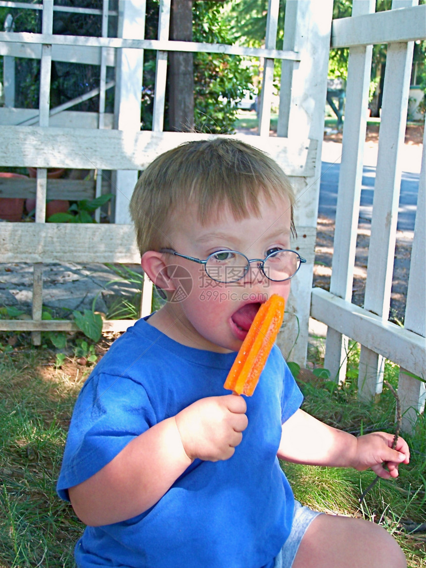 得了唐氏综合症的男孩 吃冰棒男生丘陵眼镜短裤蓝色男性生活青年乐趣橙子图片