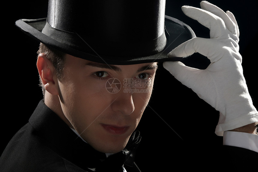 戴高帽的年轻魔术师黑色闲暇男性帽子游戏白色娱乐男人手指手势图片