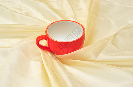 红色杯子在黄金织物的炼金场布料陶器风格用具茶碗纺织品瓷器奢华装饰丝绸背景图片