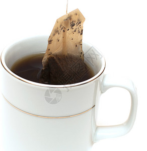 一杯茶杯子茶包棕色黑色标签白色宏观饮料反射背景图片