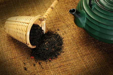 中国茶壶和配有草药茶叶的乌龙勺文化美食陶瓷柳条草本植物红茶树叶香味输液器背景