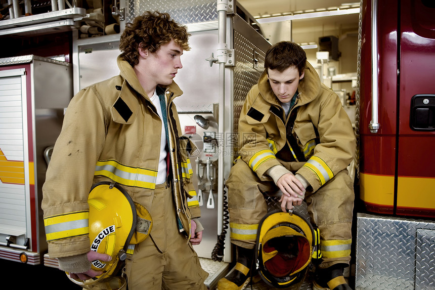 两个年轻的消防员服务消防队员灾难头盔救援图片