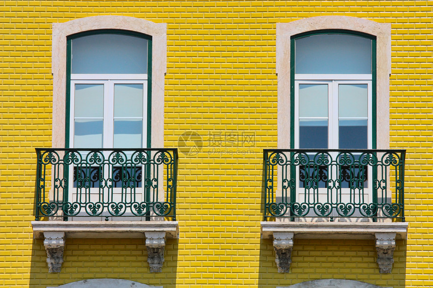 橙色活墙上的两扇窗户框架房子建筑学黄色阳台别墅红色植物白色住宅图片