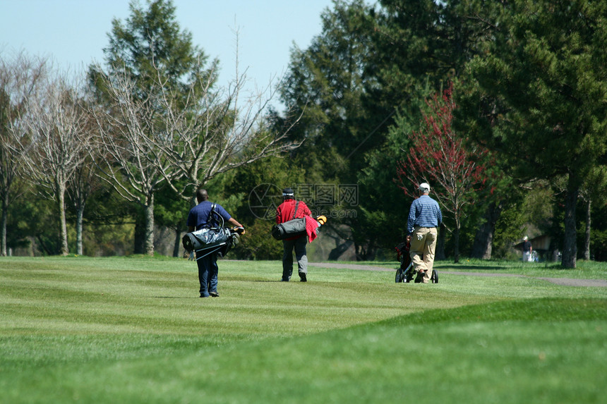 3个高尔夫球手走在大街上图片