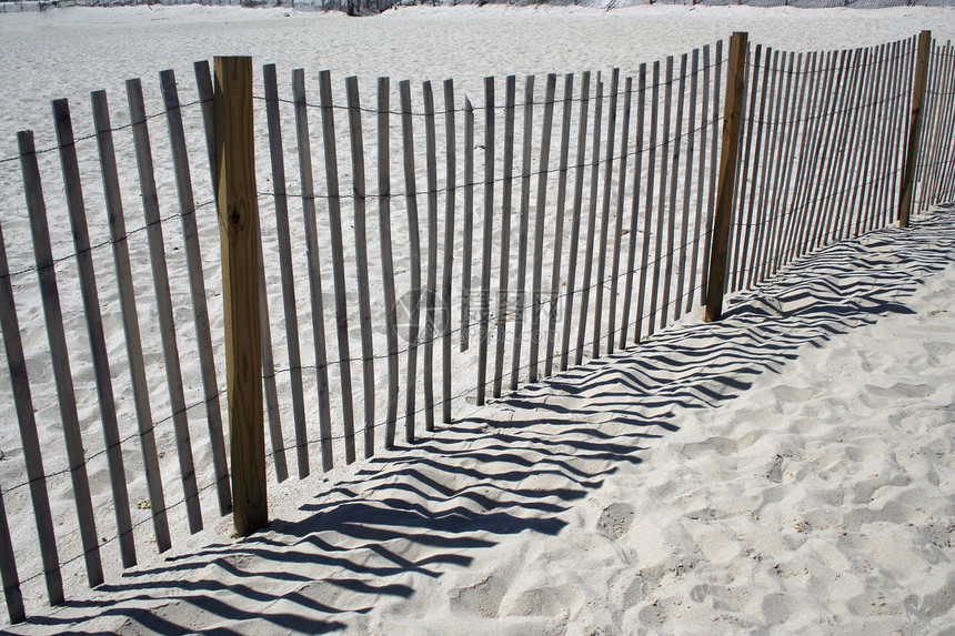 沙滩上的栅栏假期梳子阴影海岸线日落太阳场景海滩海洋海岸图片