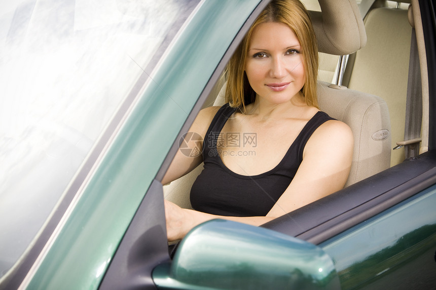 车上的漂亮女人微笑司机女士驾驶绿色窗户商业金发女郎商务金发图片