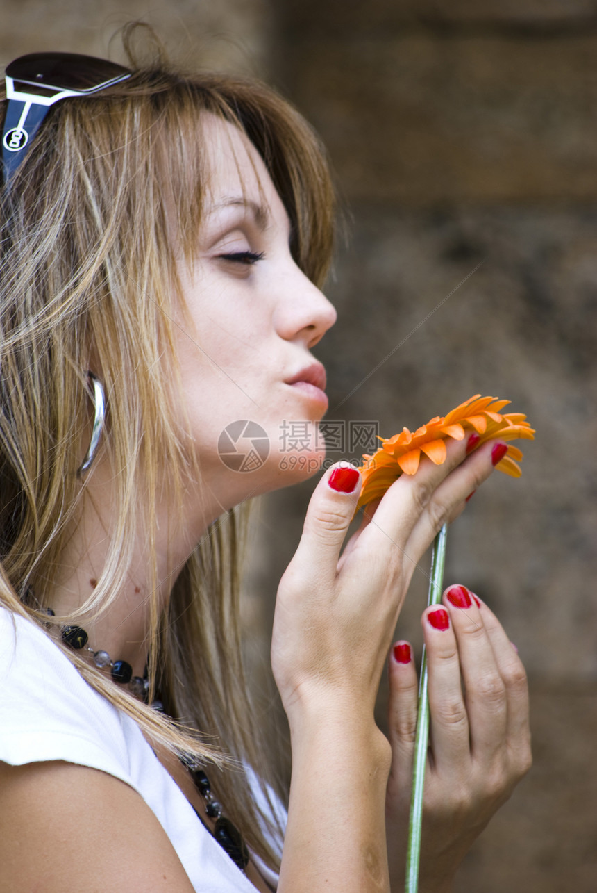 有花的美丽的年轻女子头发蓝色皮肤金发森林喜悦情感金发女郎橙子活力图片