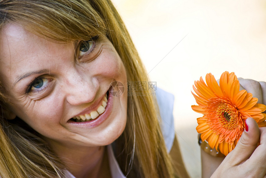 有花的美丽的年轻女子皮肤喜悦橙子生活护理衣服公园金发女性森林图片