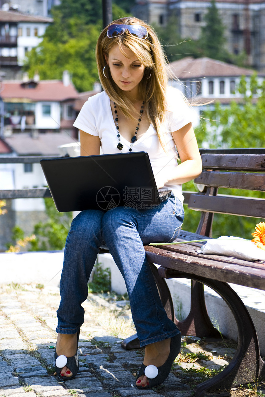 携带手提笔记本电脑的年轻美女头发微笑公园金发女郎眼睛喜悦美丽幸福蓝色商业图片