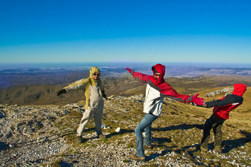 在山上快乐的徒步旅行者 玩着强风图片