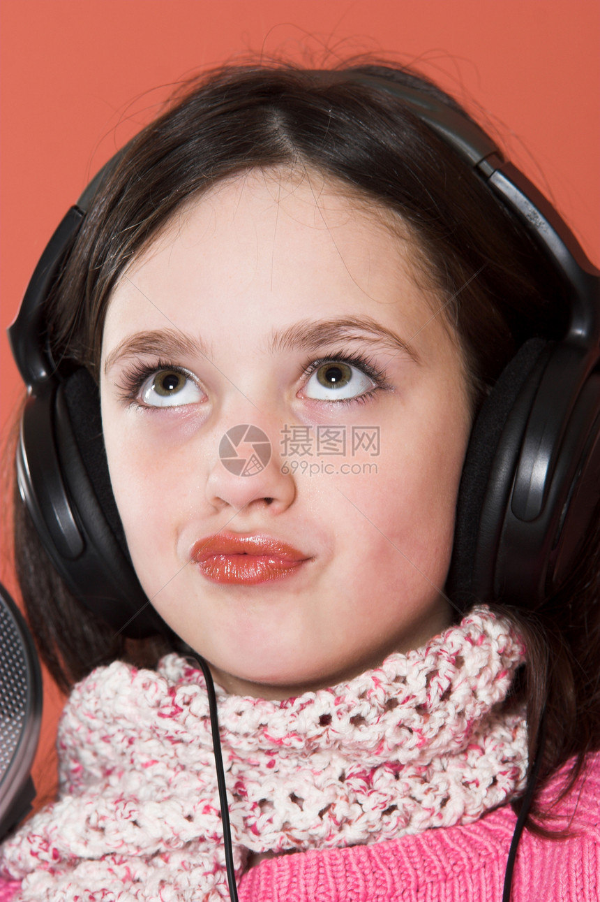 女孩用耳机听音乐微笑美丽娱乐女性孩子童年快乐乐趣技术女儿图片