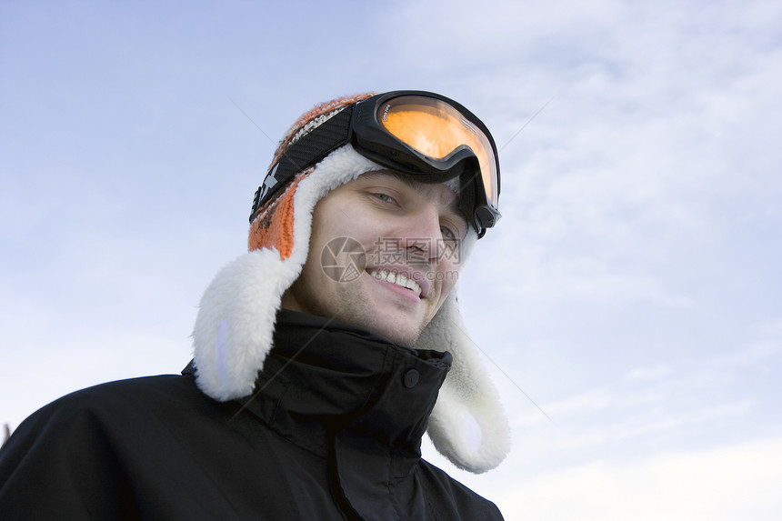 身戴滑雪眼镜和冬帽的青年男子图片