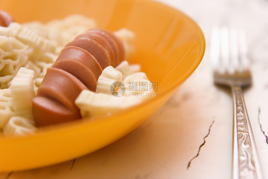 香肠和通心粉插头食物盘子黄色桌子大理石晚餐淀粉图片