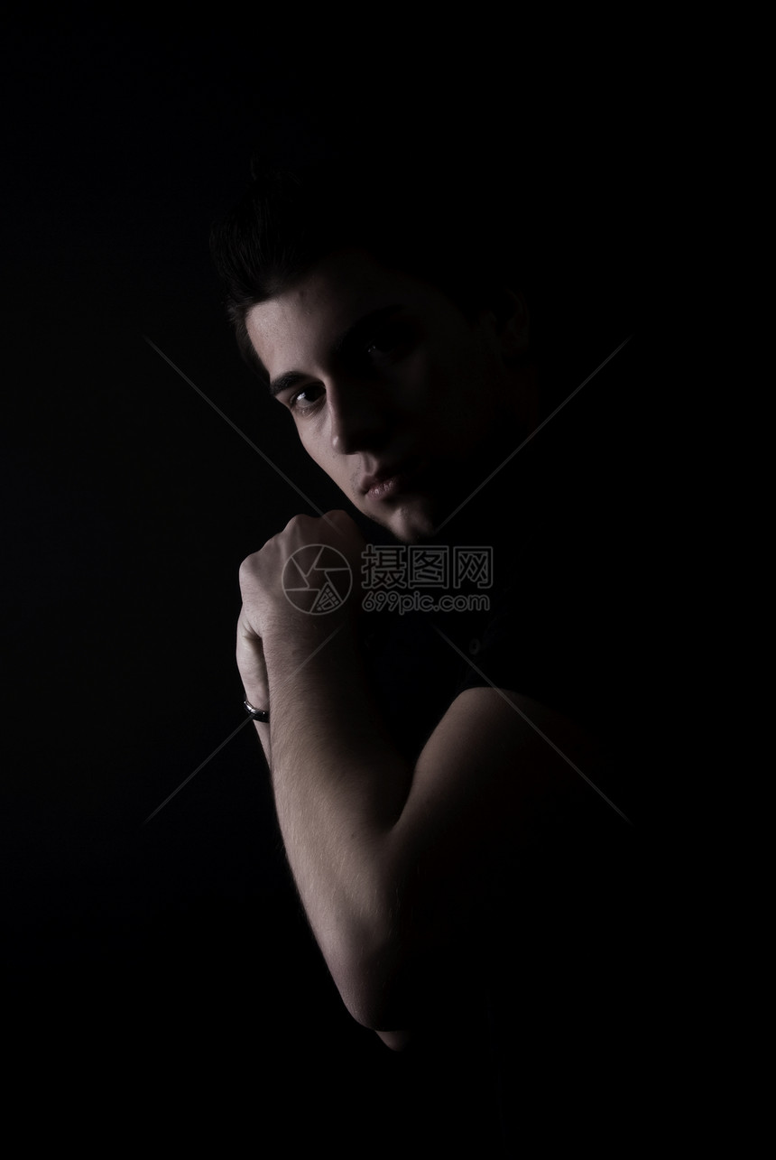 一位年轻人的肖像男人阴影隐藏愁云拳头斗争船尾男性黑暗工作室图片
