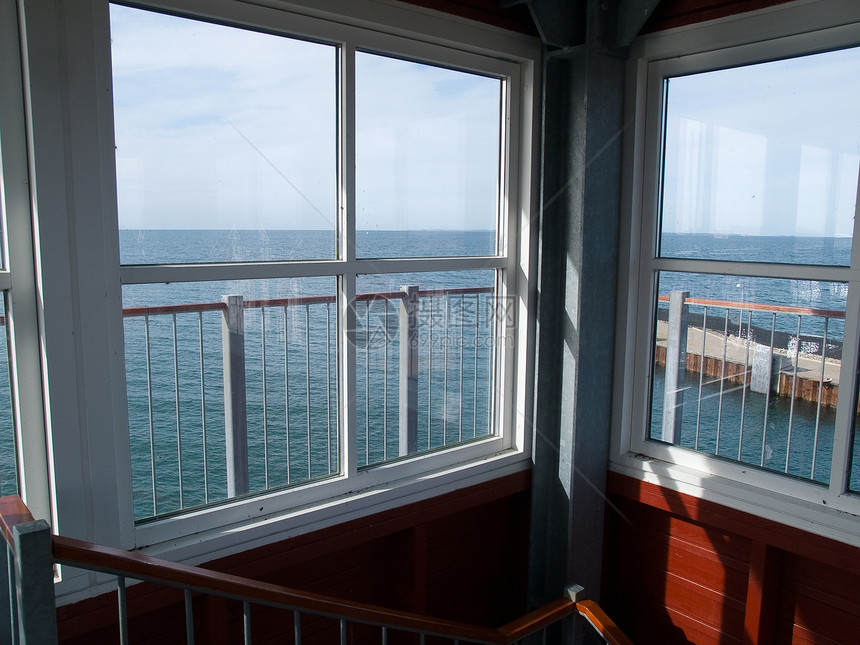 透过窗口向外看望海洋旅行房子闲暇天空蓝色框架窗户风景波浪海滩图片
