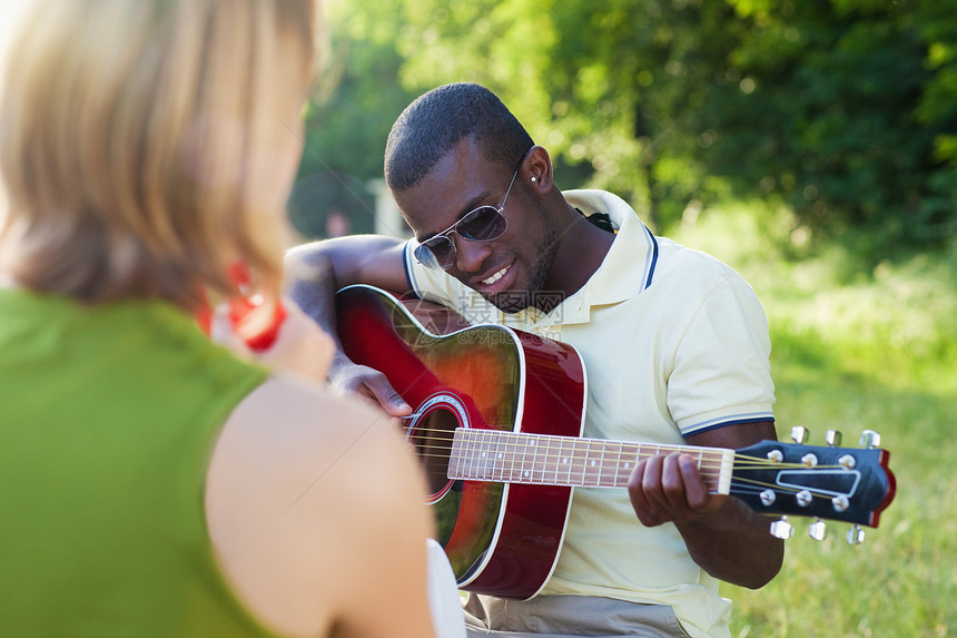 玩音乐的朋友男性男人公园吉他年轻人女士微笑快乐活动金发图片